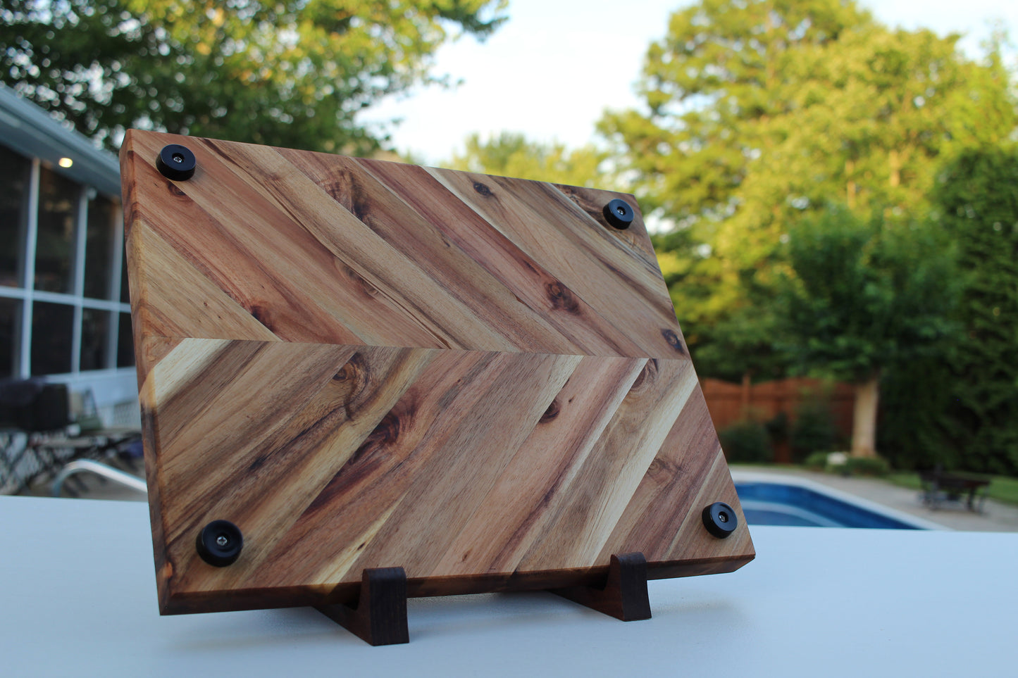 Wooden cutting board with geometric pattern on a stand outdoors